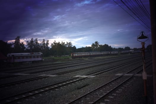 A colorful sunup above a small train station in thailand