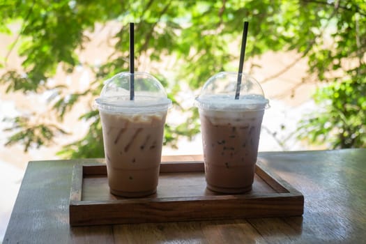Iced coffee on wooden outdoors table, stock photo