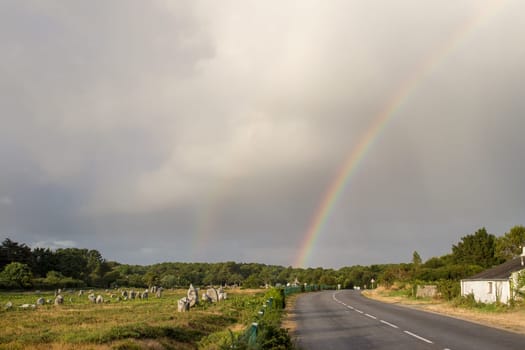 Rainbow over Alignments of Menec - rows of Menhirs - standing stones - the largest megalithic site in the world near Carnac in Brittany, France.