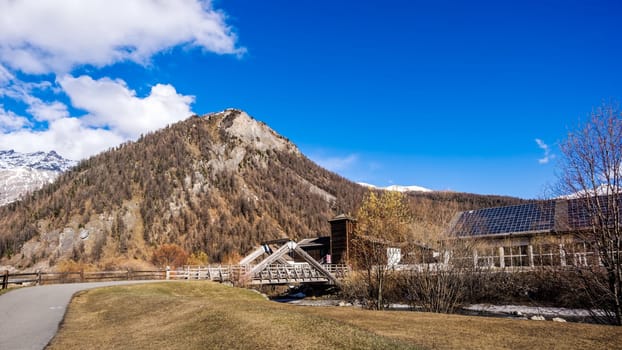 Beautiful mountain valley with stream, trees, footpath and wooden bridge, Livigno is a small town and ski centre for Italian Alps, Italy