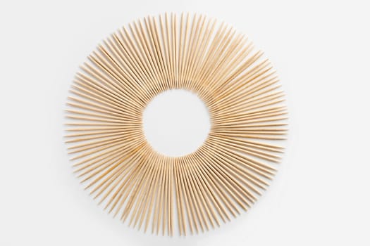 Circle of birch wooden toothpicks on a white background