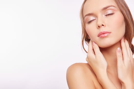 Young woman with natural makeup touching her face