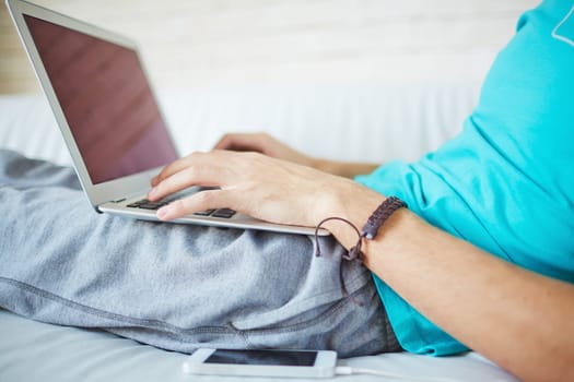 Young man typing while having rest