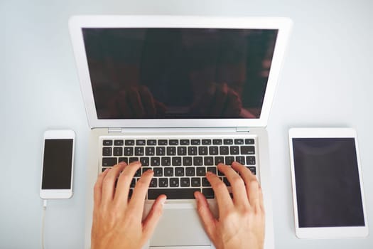 Human hands typing on laptop keypad