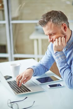 Serious white collar worker using laptop