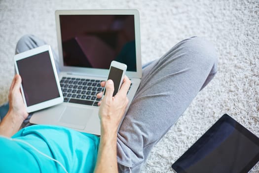 Young man with cellphone, touchpad and laptop