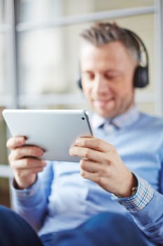 Restful businessman holding touchpad