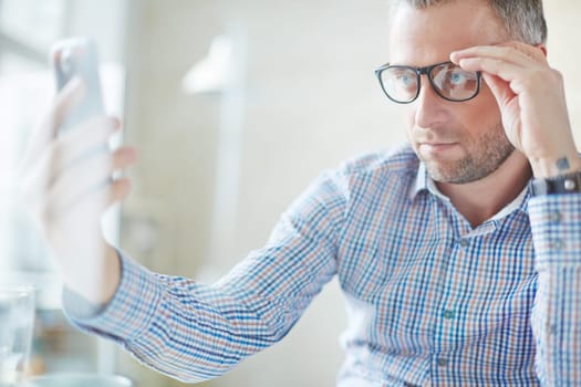 Businessman in casualwear making selfie on cellphone