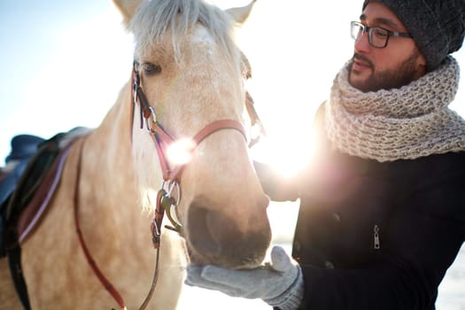 Young man in winterwear and his horse