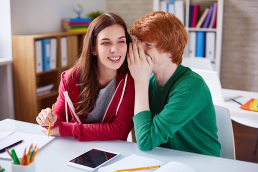 Handsome guy whispering his girlfriend something curious