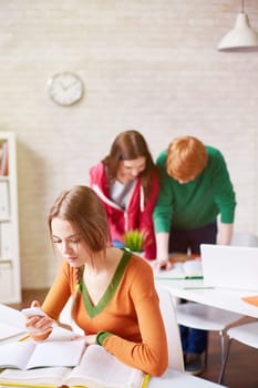 Clever student using smartphone while preparing for seminar in college library