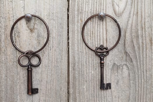 Old rusty key hanging on wooden wall