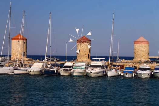 Historic windmills and boats on the sea in grece