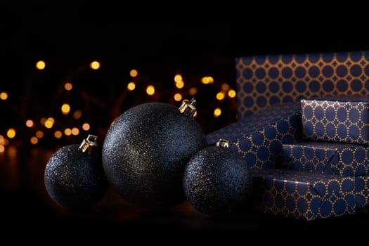 Gift boxes, Christmas decoration with LED lights garland on a black background. Christmas and New Year shopping. Greeting card