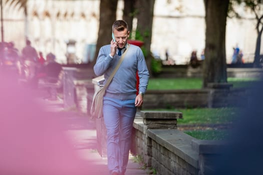Businessman walking to work while talking on the phone.