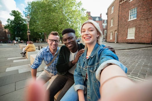 A selfie shot of two men and a woman, the woman is taking the selfie.