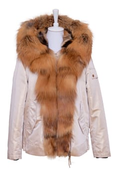 Fur clothes isolated. A stylish and luxurious bright female winter jacket with fur hood and large collar on mannequin isolated on a white background. Winter fashion.
