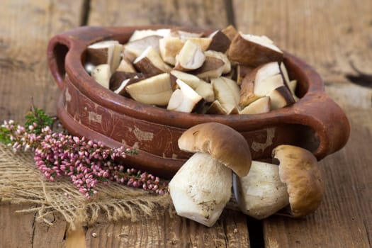 fresh mushrooms (boletus) in a bowl - wooden background