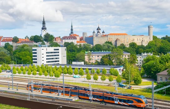 Train arrives to Tallin. Old Town of Tallin in the background. Estonia