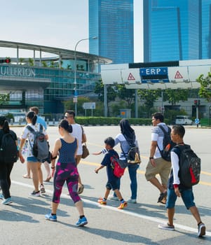 SINGAPORE - JANUARY 15, 2017: People crossing the road in Singapore. Singapore is a global commerce, finance and transport hub