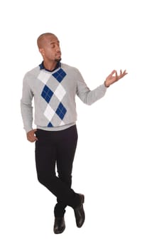 A full body image of an African American man standing in a sweater and.black pants, holding his hand out, isolated for white background.