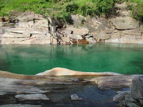 Emerald mountain water and rocks in Switzerland