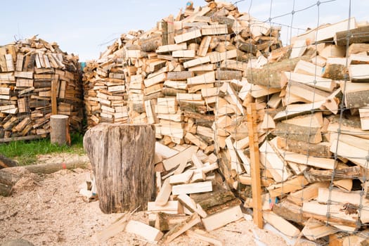 Logs in a metal grid cage with a chopping block on a lumber yard