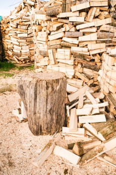Logs in a metal grid cage with a chopping block on a lumber yard