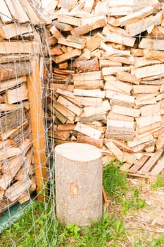 Logs in a metal grid cage with a chopping block on a lumber yard