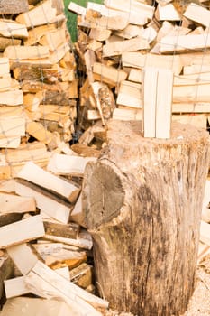 Logs in a metal grid cage with a chopping block on a lumber yard