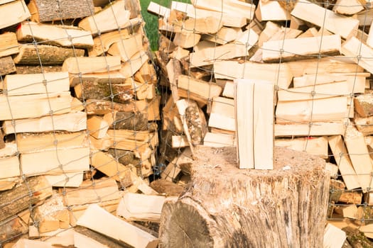Logs in a metal grid cage with a chopping block on a lumber yard
