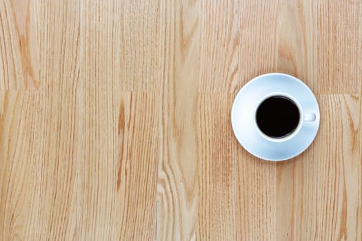 A cup of coffee on a wood table with copy space