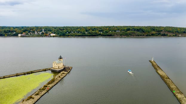 Boat ready to clear the jetty in the Hudson River at Rondout Lighthouse Kingston NY