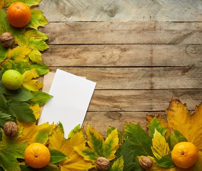 Autumn composition of colored leaves. Frame of autumn decor Poster card with yellow leaves on a wooden background. Flat lay, top view, copy space