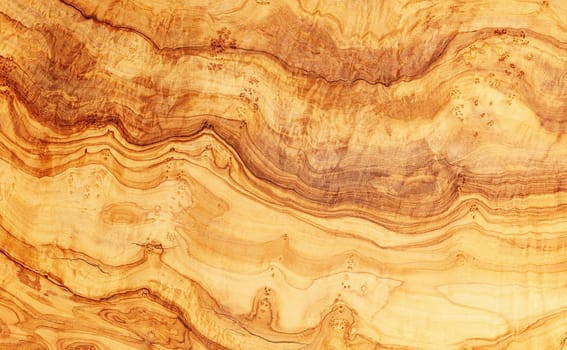 Natural olive wood wavy pattern honey color background
