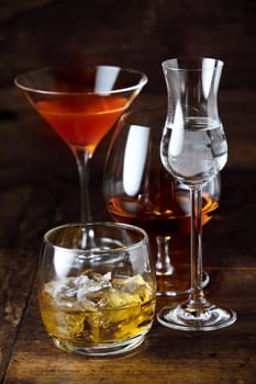 Stylish glasses of poured whisky, cognac, martini and liqueur on a pub or nightclub counter in vertical format