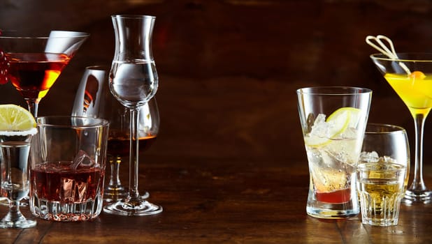 Panorama banner with a variety of alcoholic beverages and cocktails in stylish glasses with central copy space