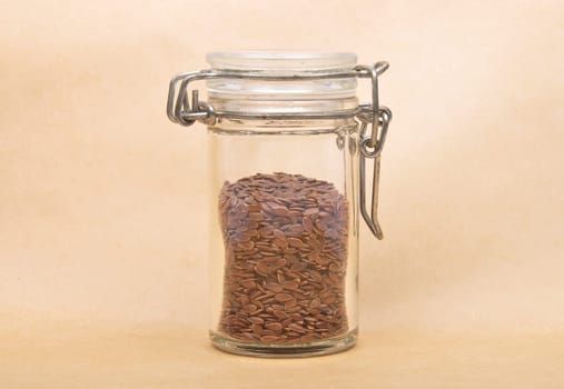 Linseed in glass on brown background