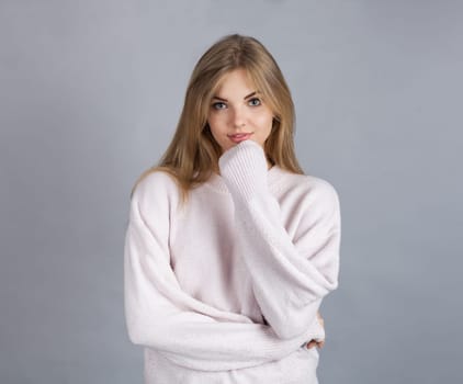 Young blonde girl, isolated on grey