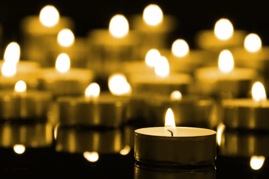 Candles on christmas night signifying hope. Gold. Background.With selective focus.