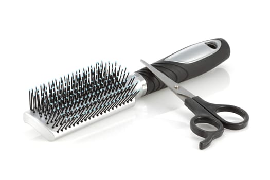 A hair brush and scissors isolated on white