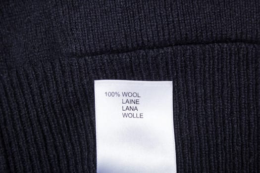 100 wool label on the sweater dark blue wool fabric.