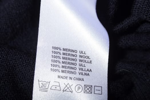 100 merino wool label on the sweater dark blue wool fabric.
