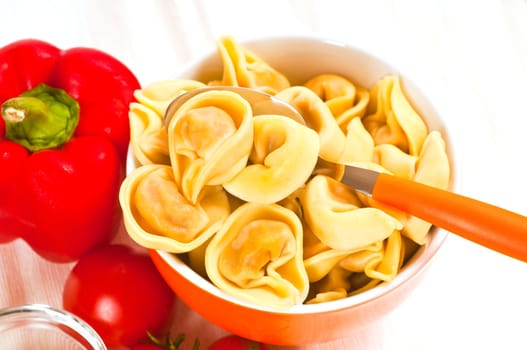 Tortellini with tomato sauce in front of white background