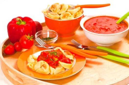 Tortellini with tomato sauce in front of white background