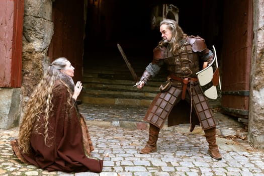 Aggressive Knight threatens woman with his sword