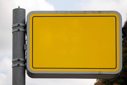 Yellow blank sign hanging on a metal post