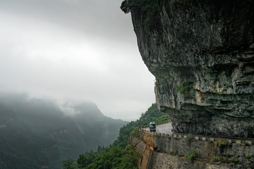 Small bus taking dangerous sharp turn on the winding road of 99 turns to the top of the Tianmen Mountain, Zhangjiajie