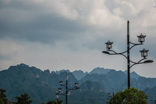 Lampposts on the street in Wulingyuan with the stunningly beautiful rocky karst mountain formations in the background, Hunan Province, China