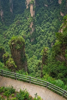 Vertical view of the walking path with spectacular views over stone pillars of Tianzi mountains and Greatest Natural Bridge in Zhangjiajie National park, famous tourist attraction, Wulingyuan, Hunan Province, China